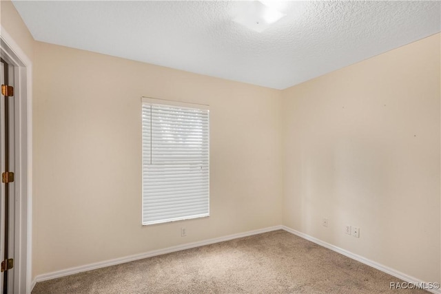 spare room featuring carpet floors and a textured ceiling