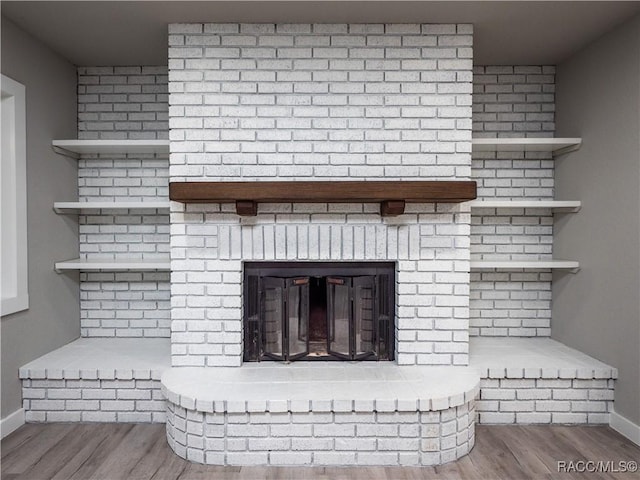 room details with a brick fireplace and wood-type flooring