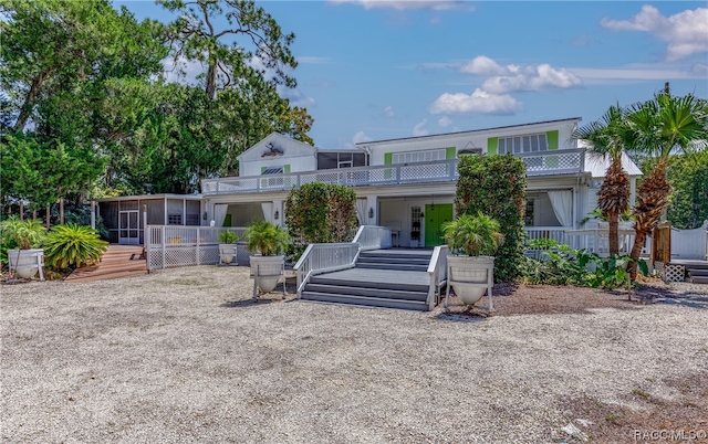 back of property featuring a sunroom and a balcony