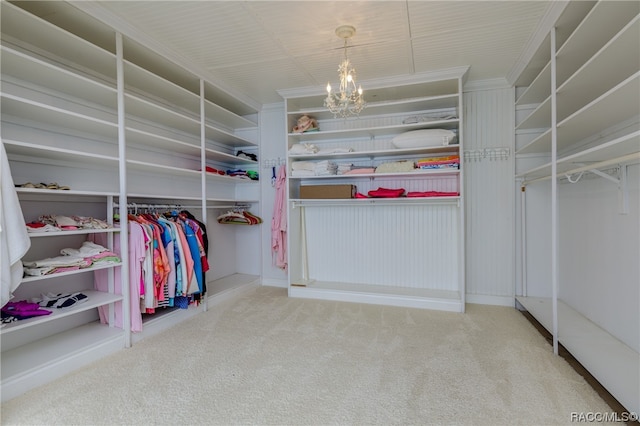 spacious closet featuring carpet flooring and a chandelier