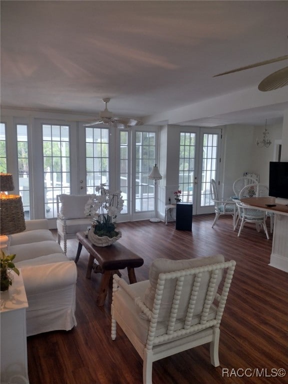 living room with french doors, ceiling fan with notable chandelier, and dark hardwood / wood-style floors