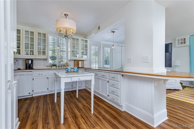 kitchen with white cabinets, a kitchen bar, hanging light fixtures, and dishwasher