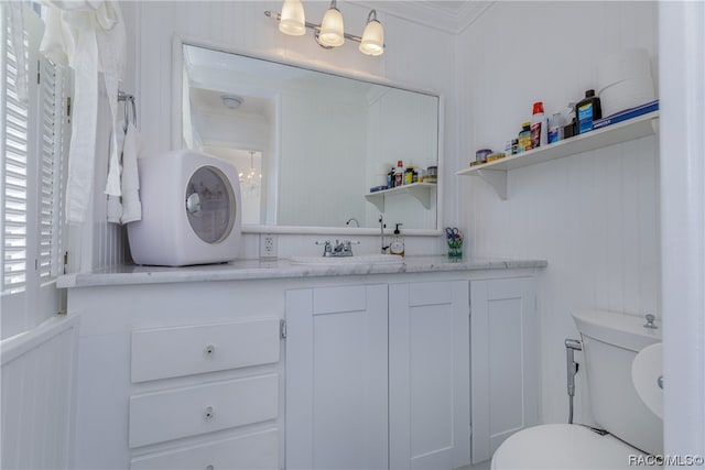 bathroom with vanity, toilet, and ornamental molding