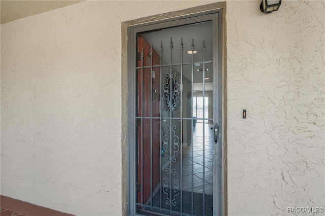 doorway to property featuring stucco siding