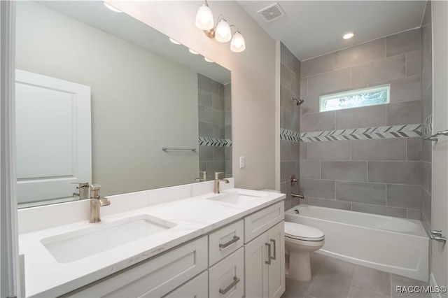 full bathroom featuring tiled shower / bath, vanity, toilet, and tile patterned flooring