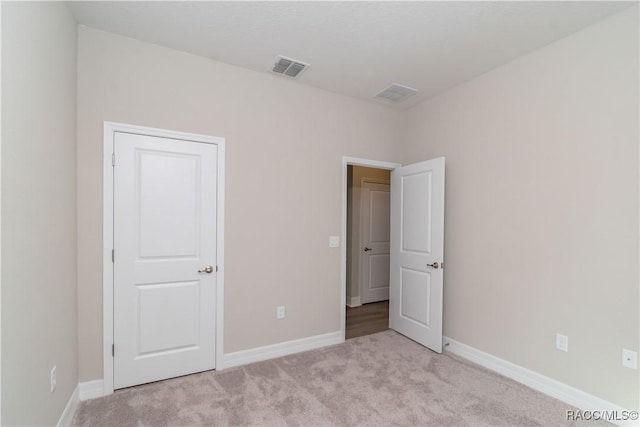 unfurnished bedroom featuring light colored carpet