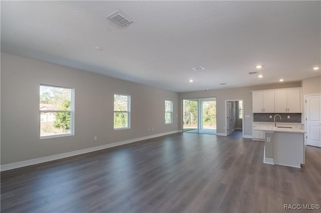 unfurnished living room with dark hardwood / wood-style flooring and sink