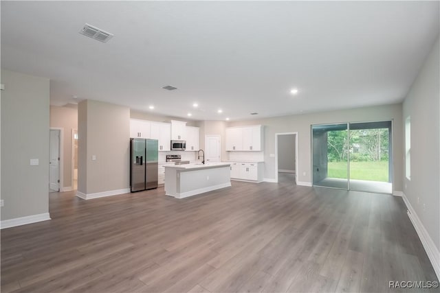 unfurnished living room featuring wood-type flooring and sink