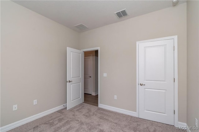 unfurnished bedroom featuring light carpet