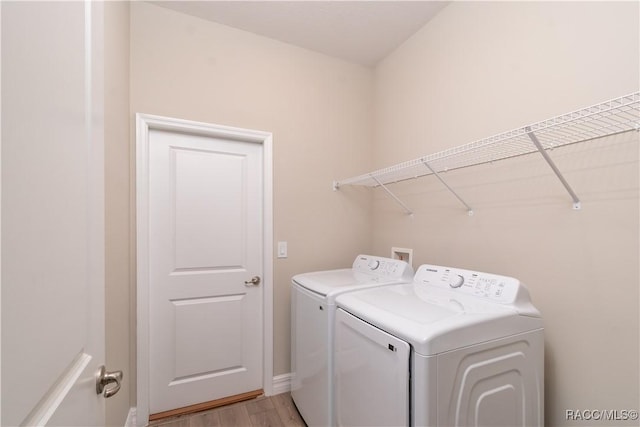 washroom with light wood-type flooring and separate washer and dryer