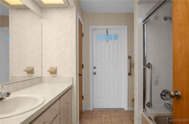 bathroom featuring vanity, tile patterned floors, and bath / shower combo with glass door