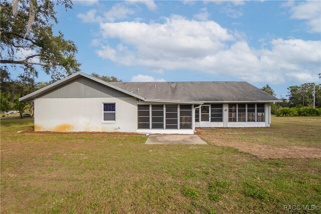 rear view of property featuring a sunroom and a yard