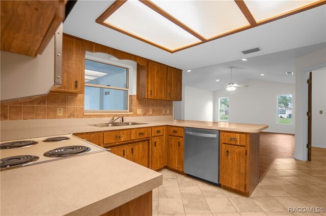 kitchen with dishwasher, lofted ceiling, backsplash, sink, and kitchen peninsula