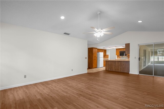 unfurnished living room featuring ceiling fan, light hardwood / wood-style floors, and lofted ceiling