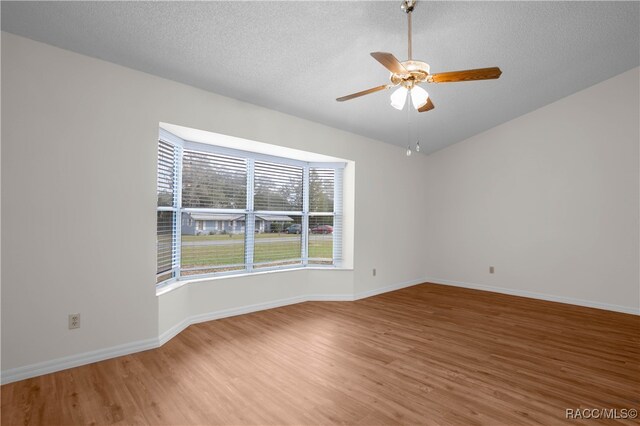 spare room with ceiling fan, wood-type flooring, and a textured ceiling