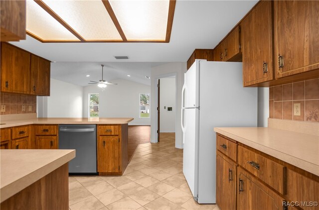 kitchen featuring decorative backsplash, vaulted ceiling, ceiling fan, light tile patterned floors, and dishwasher