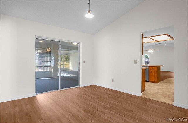 spare room featuring ceiling fan, light hardwood / wood-style flooring, and lofted ceiling