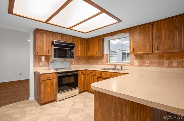 kitchen featuring electric range, light tile patterned flooring, sink, and tasteful backsplash