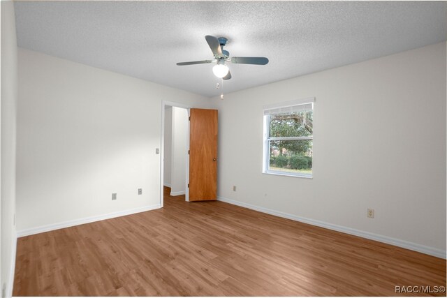 unfurnished room with ceiling fan, light hardwood / wood-style floors, and a textured ceiling