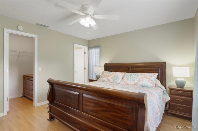 3570 E Cove Park Trl, Hernando, FL 34442 - bedroom featuring light wood-style floors, a walk in closet, baseboards, and a ceiling fan