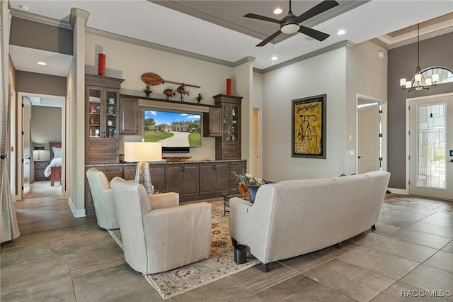 living room with crown molding, a towering ceiling, and ceiling fan with notable chandelier