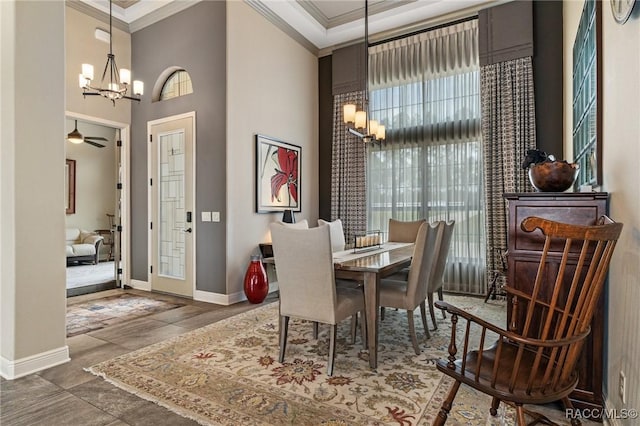 dining space featuring plenty of natural light, a towering ceiling, ceiling fan with notable chandelier, and ornamental molding