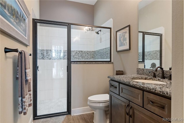 bathroom featuring vanity, hardwood / wood-style flooring, toilet, and a shower with door