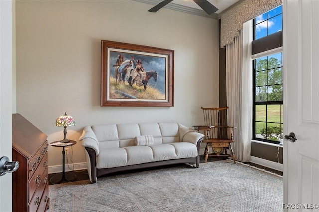 living area with ceiling fan, wood finished floors, and baseboards