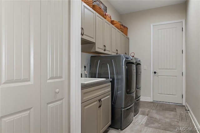 clothes washing area with cabinets and independent washer and dryer