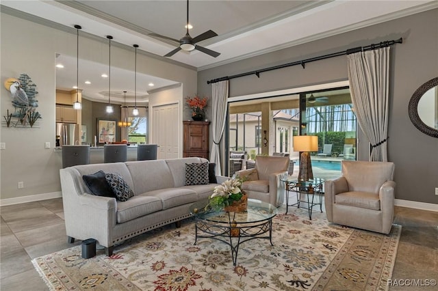 living room with ceiling fan, a raised ceiling, and crown molding