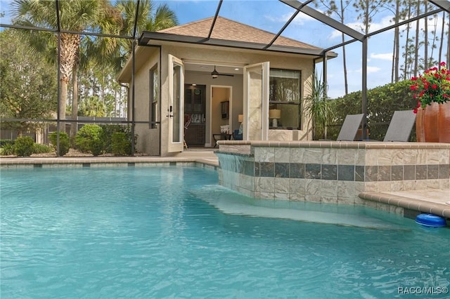 view of swimming pool featuring ceiling fan and glass enclosure