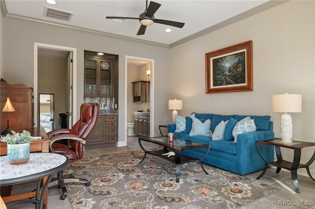 tiled living room featuring ceiling fan and ornamental molding