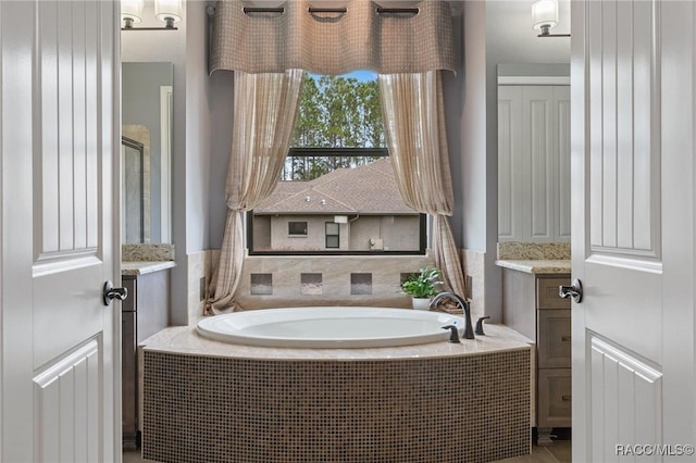 bathroom featuring vanity and a relaxing tiled tub