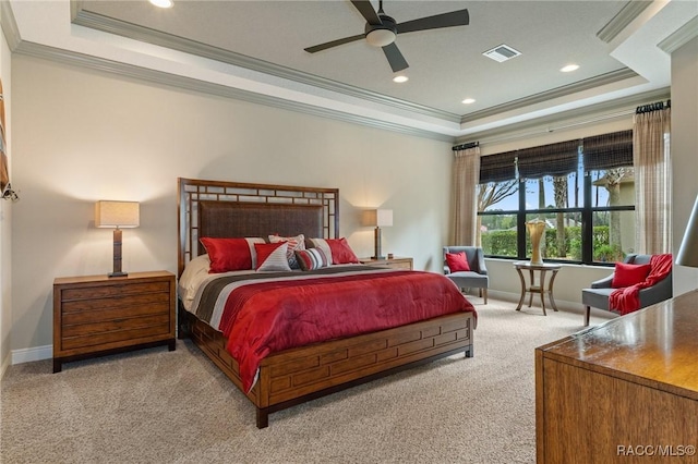 bedroom with ceiling fan, light colored carpet, ornamental molding, and a tray ceiling