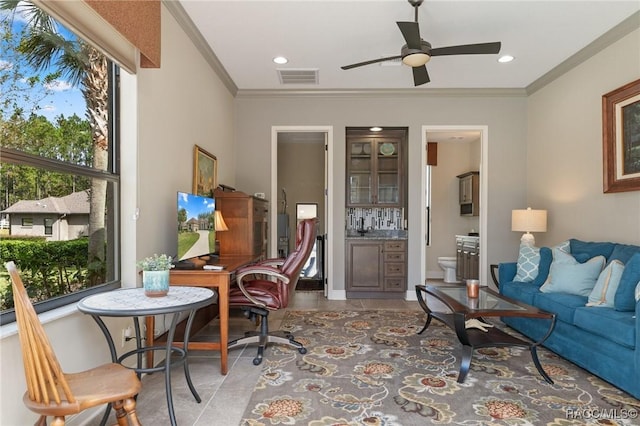 living room featuring dark tile patterned flooring, ceiling fan, and ornamental molding