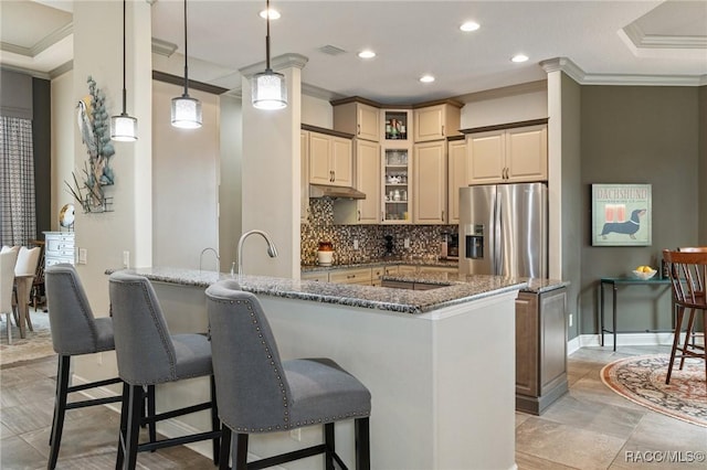 kitchen with decorative backsplash, dark stone counters, crown molding, decorative light fixtures, and stainless steel fridge with ice dispenser