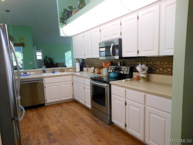 141 W Forest Oak Pl, Beverly Hills, FL 34465 - kitchen with white cabinets, light countertops, wood finished floors, stainless steel appliances, and a sink