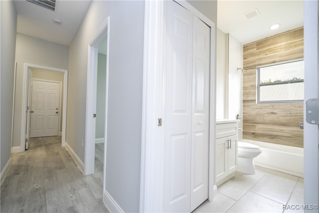 corridor with wood walls and light hardwood / wood-style flooring