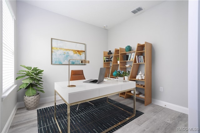 home office with light hardwood / wood-style floors