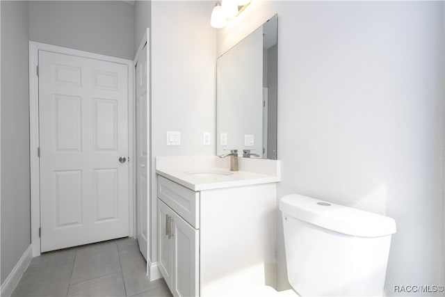 bathroom with tile patterned flooring, vanity, and toilet