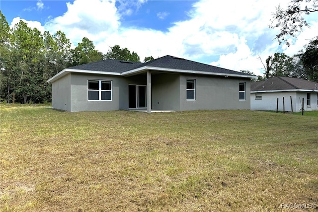 back of property with a lawn