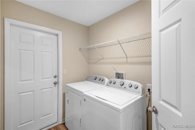 clothes washing area with washer and clothes dryer and light hardwood / wood-style floors