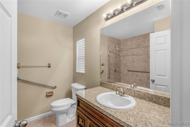 bathroom with a textured ceiling, vanity, toilet, and tile patterned floors