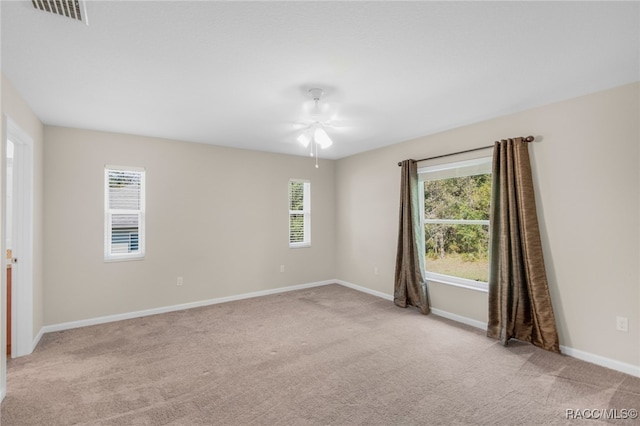 carpeted spare room featuring ceiling fan