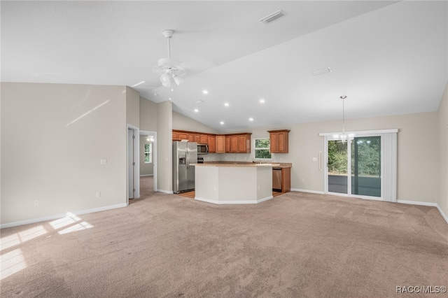 kitchen with stainless steel appliances, pendant lighting, lofted ceiling, a kitchen island, and ceiling fan with notable chandelier