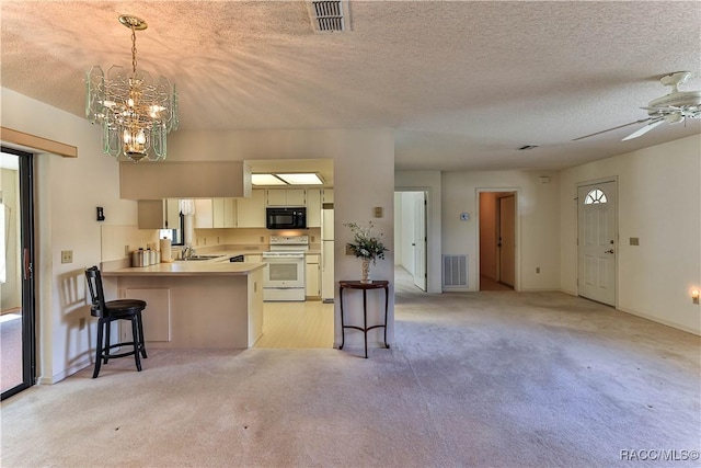 5618 W Hesse Ct, Homosassa, FL 34448 - kitchen with light colored carpet, visible vents, a sink, white appliances, and a peninsula