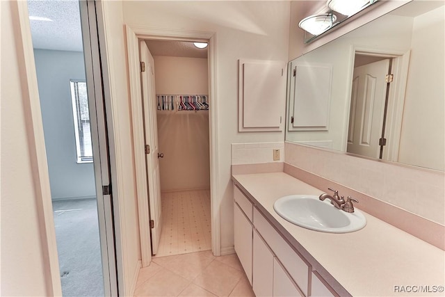 5618 W Hesse Ct, Homosassa, FL 34448 - bathroom with a walk in closet, a textured ceiling, and vanity