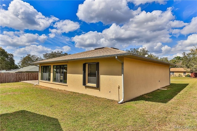 5618 W Hesse Ct, Homosassa, FL 34448 - view of home's exterior featuring a yard, a shingled roof, fence, and stucco siding
