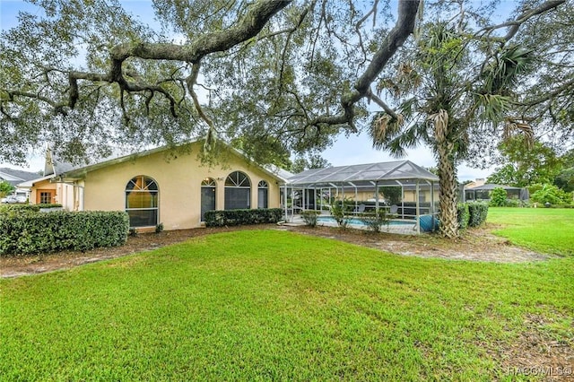 640 E Hartford St, Hernando, FL 34442 - back of house with stucco siding, a lawn, an outdoor pool, and glass enclosure