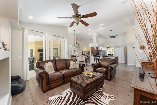 living room featuring ceiling fan and vaulted ceiling